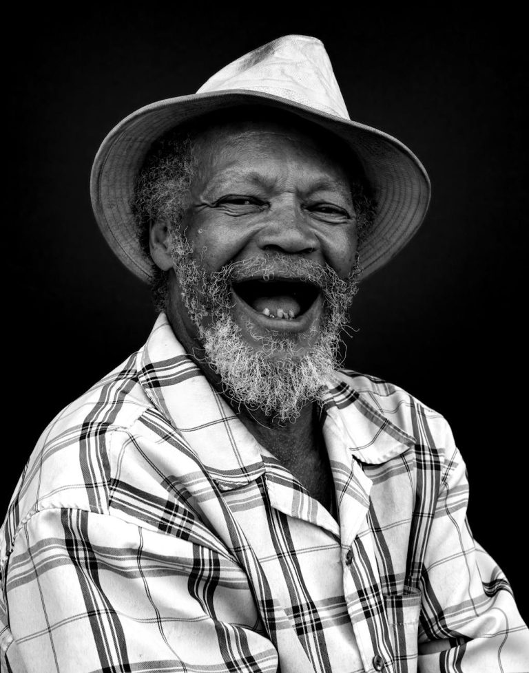joyful senior man in plaid shirt and hat